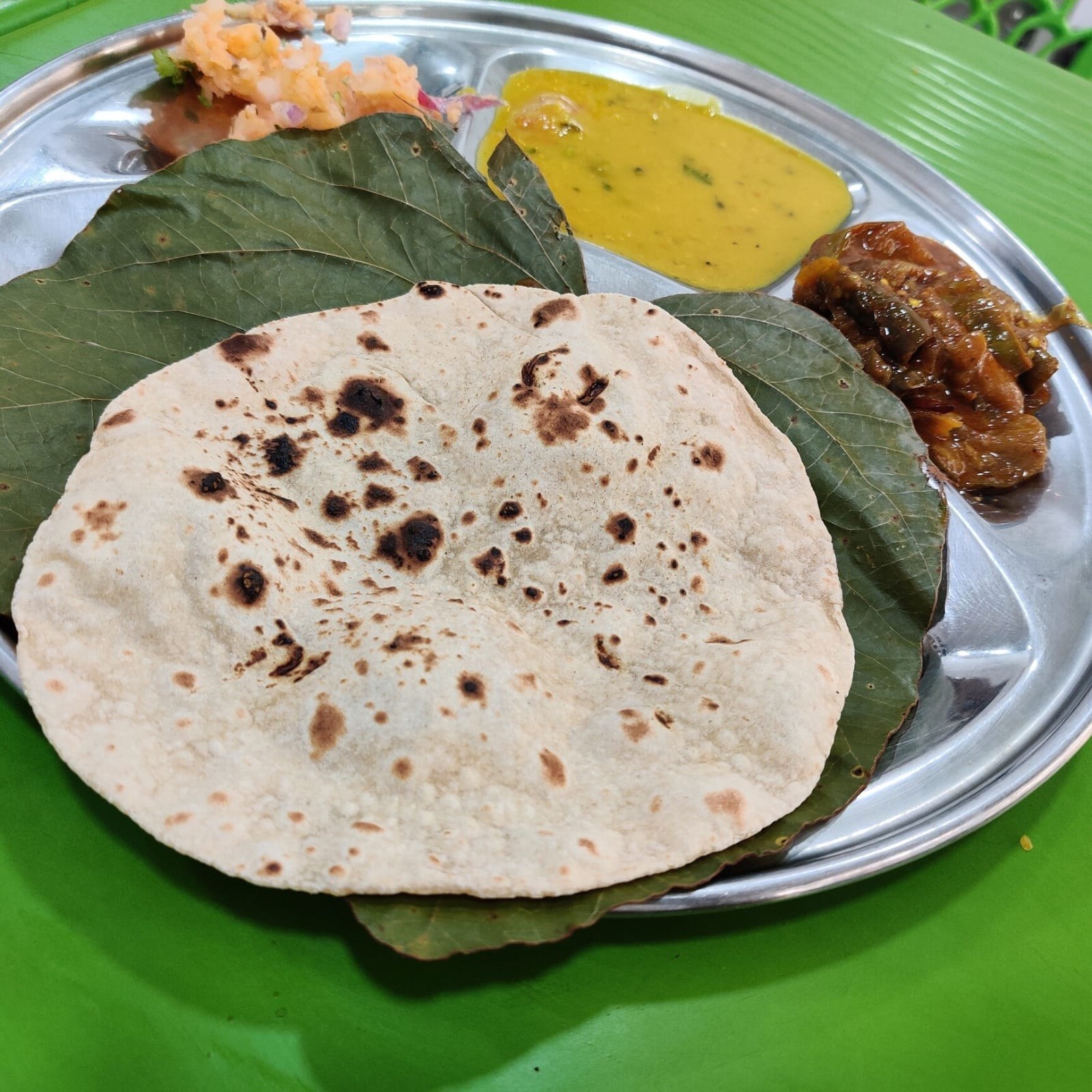 Jolada rotti meal with palya, sambar and brinjal curry served on a steel plate at Bhavani Homestay